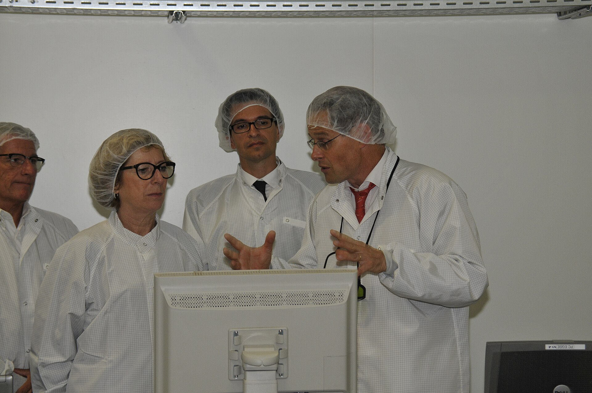Engineers working inside a semiconductor fabrication plant in cleanroom suits
